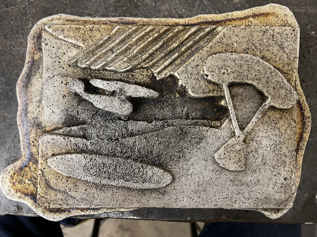Raw aluminum casting with raised parachute and oval relief details