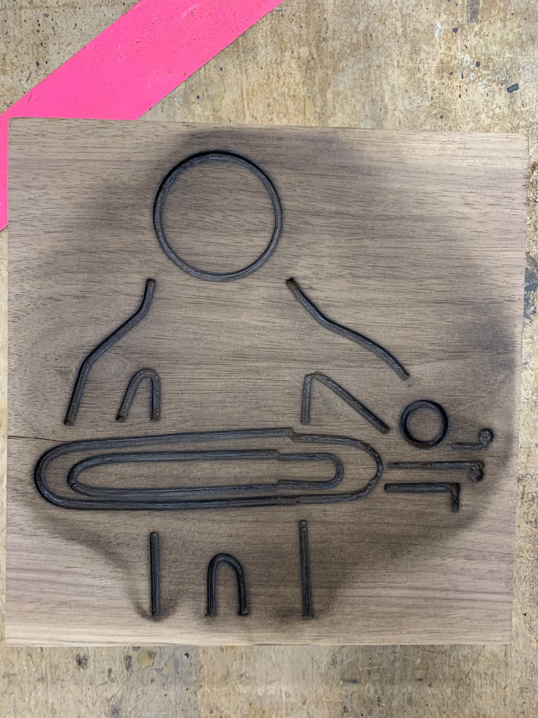 Square wood block branded with custom figure logo from the branding iron