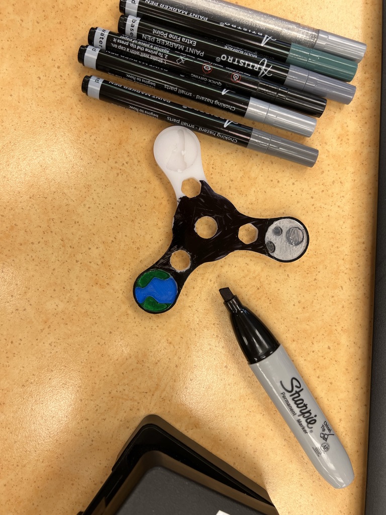 Work-in-progress painting of celestial bodies on CNC-machined HDPE fidget spinner